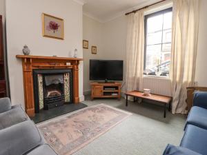 a living room with a fireplace and a television at Ribble Valley Cottage in Preston