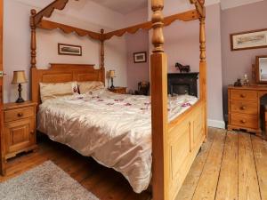 a bedroom with a large bed with a wooden frame at Ribble Valley Cottage in Preston