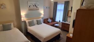 リザム・セント・アンズにあるThe Sea Croft Bed Breakfast & Barのベッド2台とソファが備わる小さなホテルルームです。