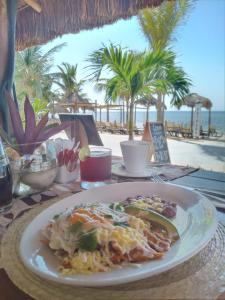 a plate of food on a table next to the beach at Quinto Sole by GuruHotel in Mahahual
