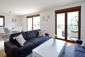 a living room with a blue couch and a table at Captain's Luxury Apartments in Mostar