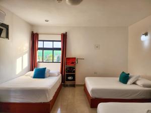 Duas camas num quarto com uma janela em Fitz-Mar em Isla Mujeres
