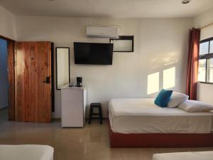 um quarto com uma cama e uma televisão de ecrã plano em Fitz-Mar em Isla Mujeres