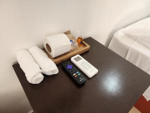 a table with a remote control and towels on a bed at Fitz-Mar in Isla Mujeres