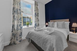 a bedroom with a bed with towels on it at The Apartments Coniston in Coniston