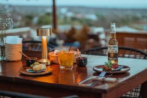 een tafel met borden en een fles bier bij Casa Terranova in Puerto Escondido