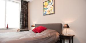 Un dormitorio con una cama con una almohada roja. en B&B Innbrugas, en Brujas