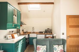 a kitchen with green cabinets and a chair in it at Hootsman in Rosedale Abbey