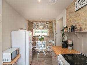 una cucina con frigorifero bianco e tavolo di The Barn a York