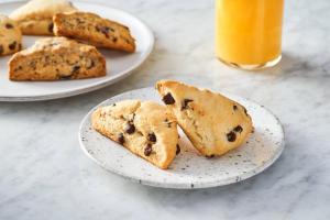 Dois pratos de bolachas de chocolate e um copo de sumo de laranja. em SpringHill Suites Galveston Island em Galveston