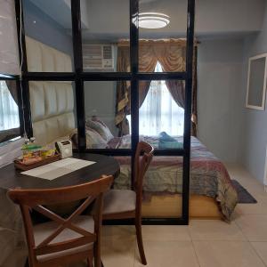 a bedroom with a bed with a table and a desk at Cozy Apartment in Cebu IT Park T2517 in Cebu City