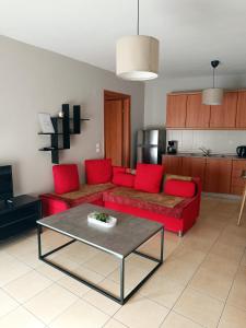 a living room with a red couch and a table at Kalvou Flat2 in Thessaloniki