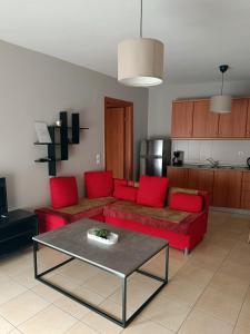 a living room with a red couch and a table at Kalvou Flat2 in Thessaloniki