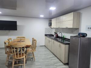 a kitchen with a wooden table and a refrigerator at alojamiento y apartamento choachi in Choachí +4 photos