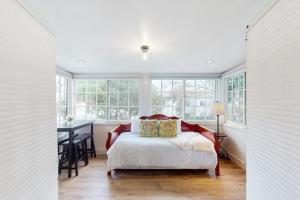 1 dormitorio con cama, mesa y ventanas en Santa Cruz, en Santa Bárbara