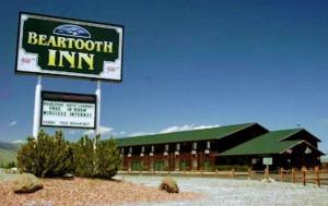 una señal para una posada de barrotes frente a un edificio en Beartooth Inn en Cody