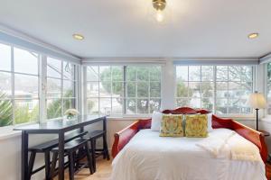 a bedroom with a bed and a table and windows at Santa Cruz in Santa Barbara +26 photos