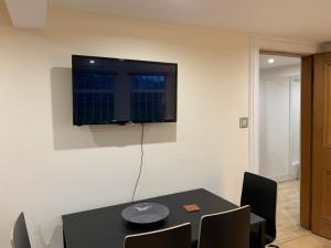 a dining room with a table and a television on a wall at The Inverleither in Edinburgh