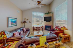a living room with a leather couch and a table at Rim Village H4 in Moab