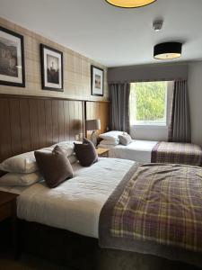 a hotel room with two beds and a window at Beaufort Hotel in Inverness