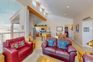 a living room with two leather couches and a kitchen at Rim Village H4 in Moab
