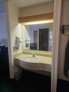 a bathroom with a sink and a large mirror at Beartooth Inn in Cody