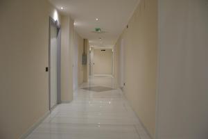 a hallway with white walls and a white tile floor at Park Hotel in Casa Francesi