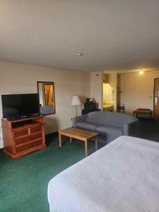 ein Hotelzimmer mit einem Bett und einem TV in der Unterkunft Beartooth Inn in Cody