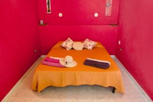 una camera rossa con un letto e asciugamani di Sabrina Suite a Milazzo