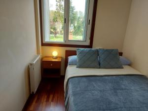 een kleine slaapkamer met een bed en een raam bij Apartamento Don Manuel 2 in Cuntis