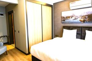 a bedroom with a bed and a painting on the wall at Sing Of Hotel & Suites Taksim Istanbul in Istanbul