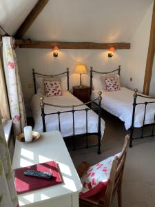 Dos camas en una habitación con una mesa y un Sidx Sidx Sidx Sidx Sidx. en Wethele Manor, en Leamington Spa