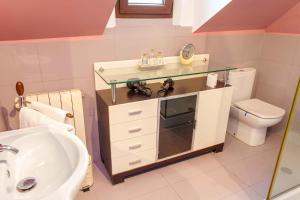 baño con lavabo y encimera de cristal en Hospedaje Villa Pilar, en Santillana del Mar