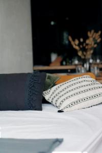 a bed with a black and white pillow on it at Charmant Appartement Les temples du Soleil in Font-Romeu-Odeillo-Via