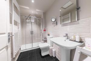a bathroom with a sink and a toilet and a shower at The Apartments Coniston in Coniston