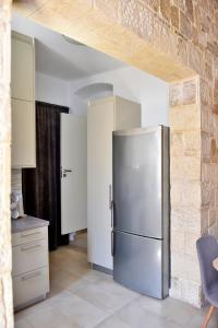 a kitchen with a stainless steel refrigerator in a room at FERENIKIS LUXURY HOUSE OLD TOWN in Rhodes Town