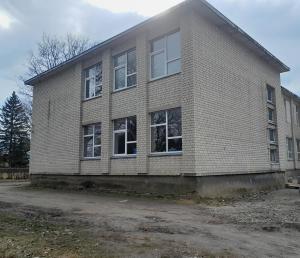 a brick building with windows on the side of it at Hostel PLUNKSA in Marijampolė