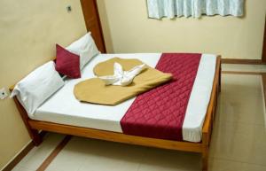 a bed with a wooden frame with a butterfly on it at Silver Homes Homestay in Alwaye