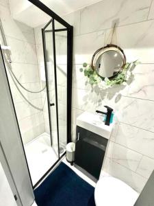 a bathroom with a shower and a sink and a mirror at Stunning 1-Bed Apartment in Lewisham SE14 in London