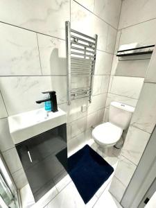 a white bathroom with a sink and a toilet at Stunning 1-Bed Apartment in Lewisham SE14 in London
