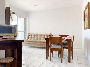 sala de estar con mesa y sofá en Resid. Clube Mar Grosso - Laguna en Laguna