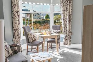 a living room with a table and chairs and a window at The Apartments Coniston in Coniston