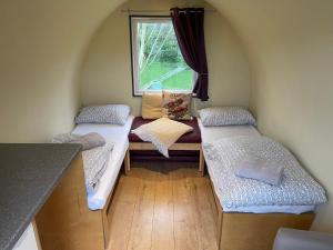 约克Belle Vista Glamping & Camping的一间小房间设有三张床,设有窗户