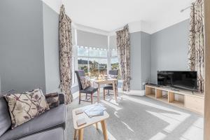 a living room with a couch and a tv and a table at The Apartments Coniston in Coniston