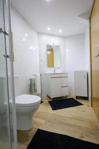 a bathroom with a toilet and a sink and a mirror at CASA ORIGENS ll in Seia