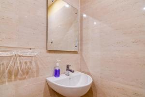 een badkamer met een witte wastafel en een spiegel bij Eco Corporate Inn 2 Rajarhat in kolkata