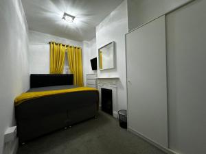 ein Schlafzimmer mit einem Bett und einem Kamin in der Unterkunft Galaxy apartments Brentwood in Brentwood