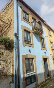 een blauw gebouw met een balkon in een straat bij CASA ORIGENS ll in Seia