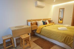 a bedroom with a bed and a desk and a mirror at CASA ORIGENS ll in Seia