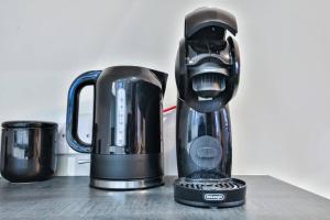 a black blender sitting on a counter next to a cup at StayRight Whitchurch Place: 2-bed Flat in Cardiff in Cardiff